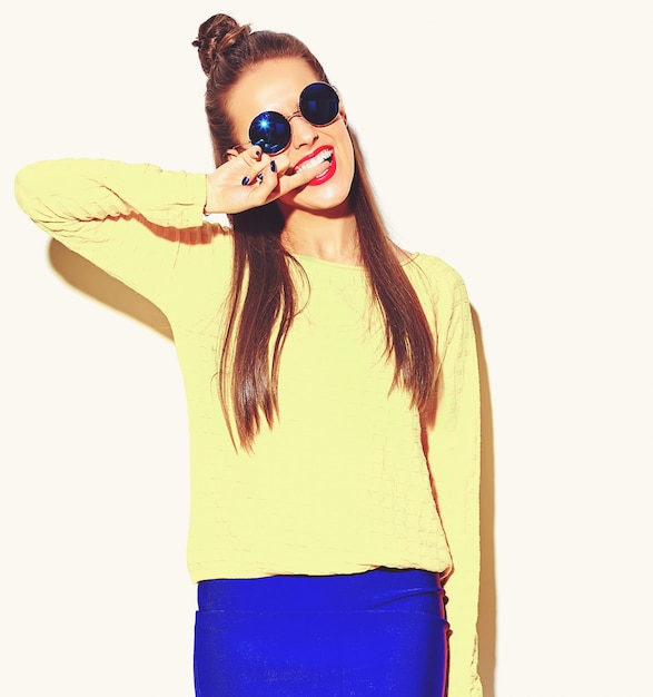 portrait of cheerful fashion smiling hipster girl going crazy in casual colorful yellow summer clothes with red lips isolated on white biting her finger