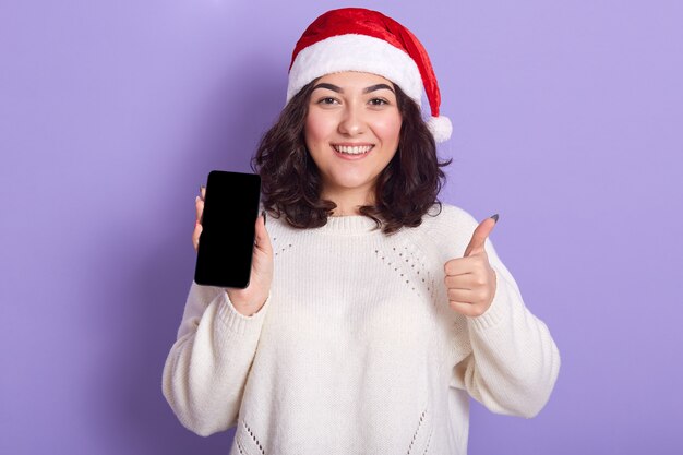 Portrait of cheerful good looking young girl with raised thumb