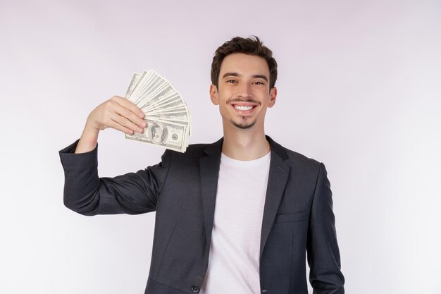 Portrait of a cheerful man holding dollar bills over white background