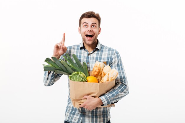 Portrait of a cheerful man holding paper bag