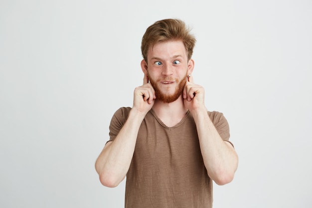 Portrait of cheerful merry young man making funny face fooling.