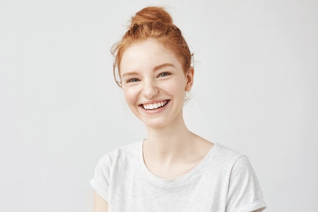 髪のお団子が笑っている陽気な赤毛の女性の肖像画。