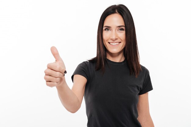 Portrait of a cheerful smiling woman giving thumbs up