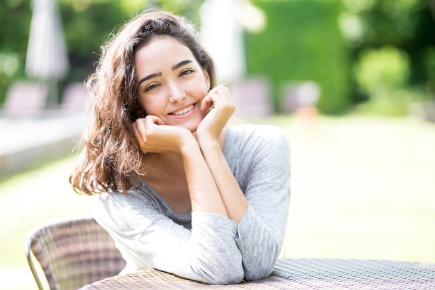 テーブルに座って明るい十代の女の子の肖像