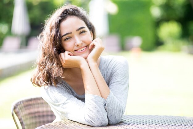 Portrait of cheerful teenage girl sitting at table