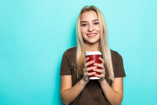 緑の壁にコーヒーとカップを保持している陽気な女性の肖像画。