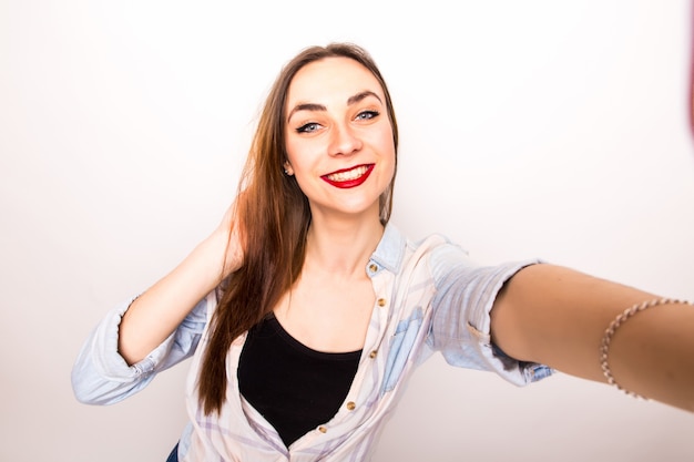 회색 위에 selfie 사진을 만드는 쾌활 한 여자의 초상화
