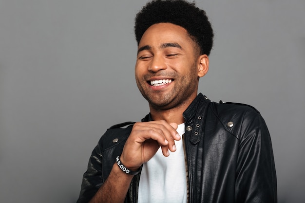 Portrait of a cheerful young african man in leather jacket