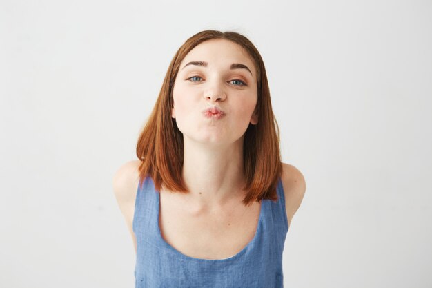 Portrait of cheerful young beautiful pretty girl sending kiss .