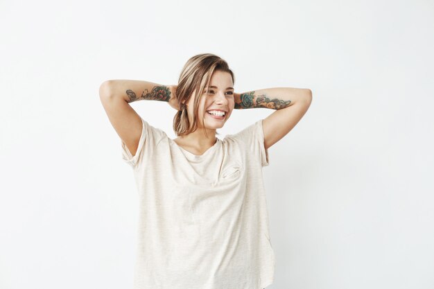 Portrait of cheerful young beautiful tattooed girl smiling posing .