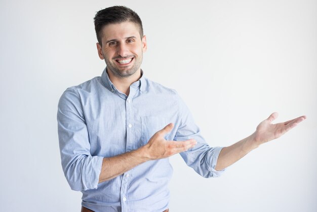 Free photo portrait of cheerful young caucasian manager showing product.