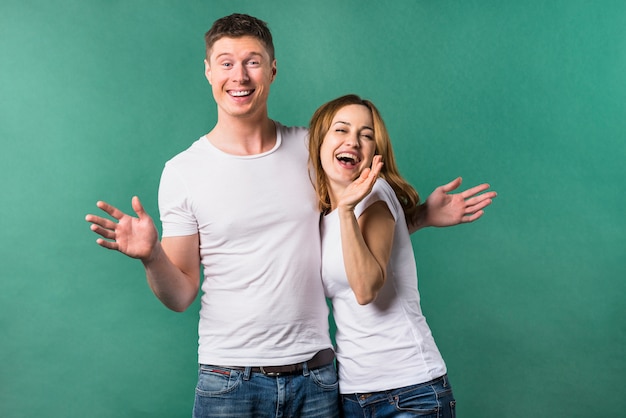 Portrait of a cheerful young couple against green background