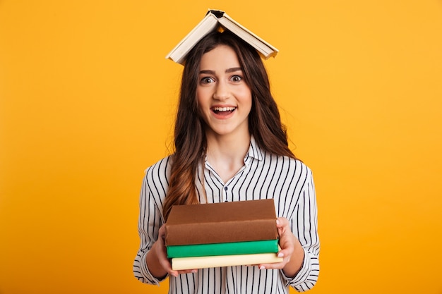 Portrait of a cheerful young girl holding books