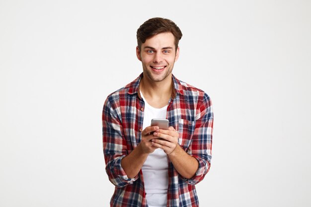 Портрет веселый молодой человек, держащий мобильный телефон