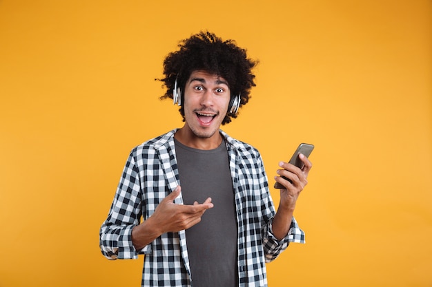 Portrait of a cheery young african man listening to music