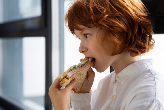 Ritratto di bambino che mangia panino a scuola