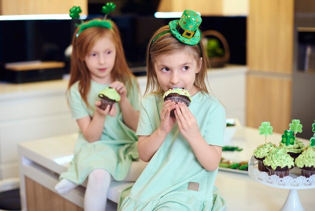 Portrait of children eating cupcake