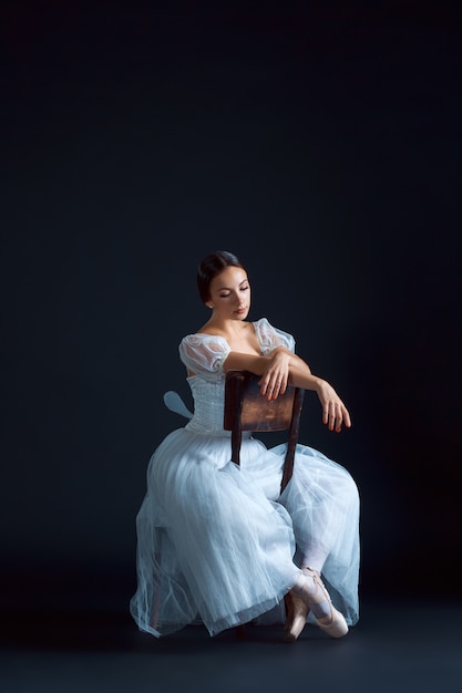 Portrait of the classical ballerina in white dress on black