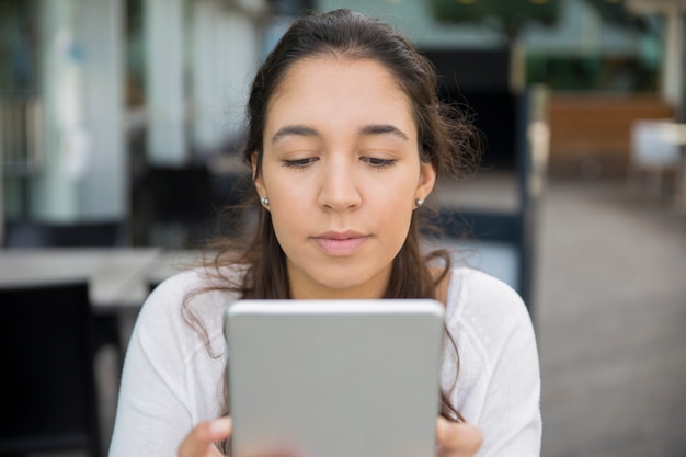 集中している10代の少女のPCタブレット上のネットワークの肖像