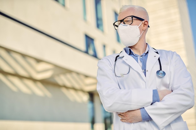 Free photo portrait of confident albino doctor with protective face mask outdoors