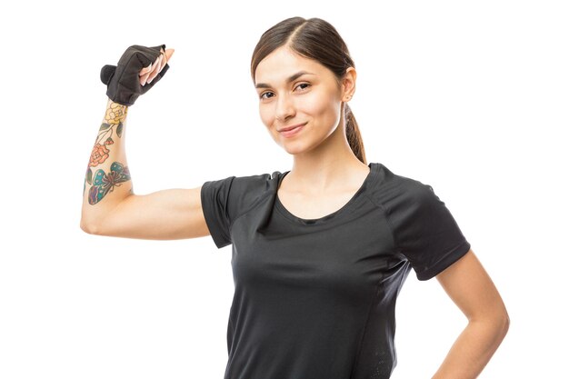 흰색 배경 위에 팔뚝을 구부리는 자신감 있는 운동 여성의 초상화