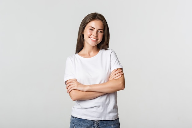 Portrait of confident attractive woman, cross arms chest and smiling pleased.