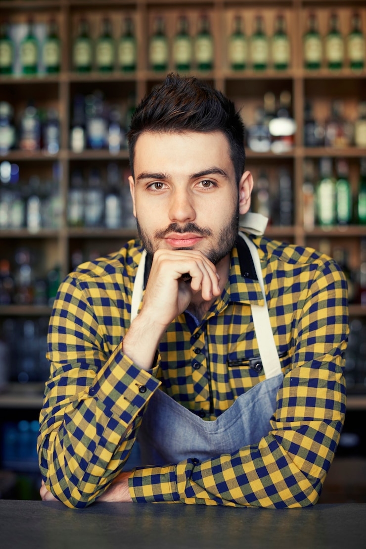 मुफ़्त फोटो portrait of confident bartender at bar counter