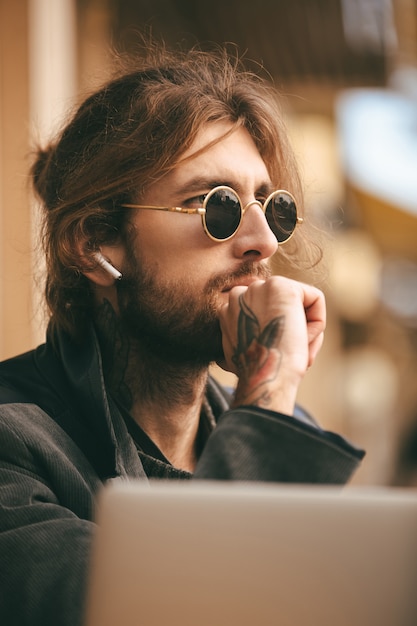 Portrait of a confident bearded man in earphones