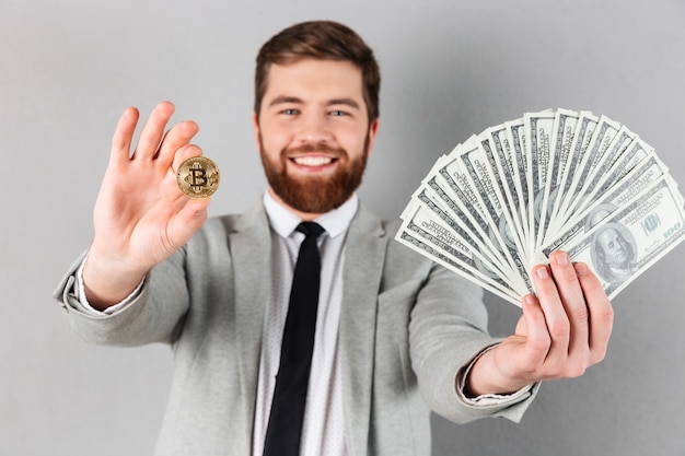 Portrait of a confident businessman showing bitcoin