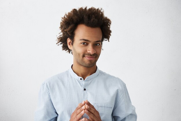 Portrait of confident businessman with curly dark hair having serious and concentrated look