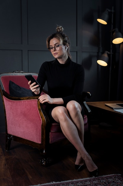 Free photo portrait of confident businesswoman checking her phone