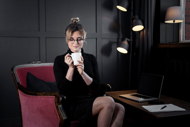 Portrait of confident businesswoman having coffee