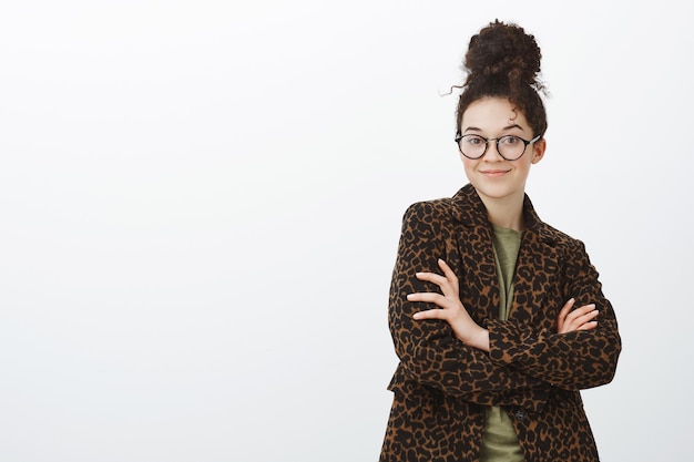 Free photo portrait of confident carefree creative female entrepreneur in stylish eyewear and leopard coat, holding hands crossed and smiling self-assured