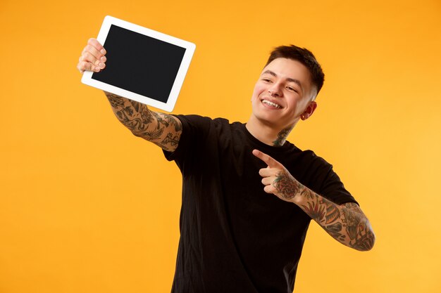 Portrait of a confident casual man showing blank screen of laptop