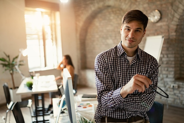 Portrait of confident entrepreneur standing in the office and looking at camera