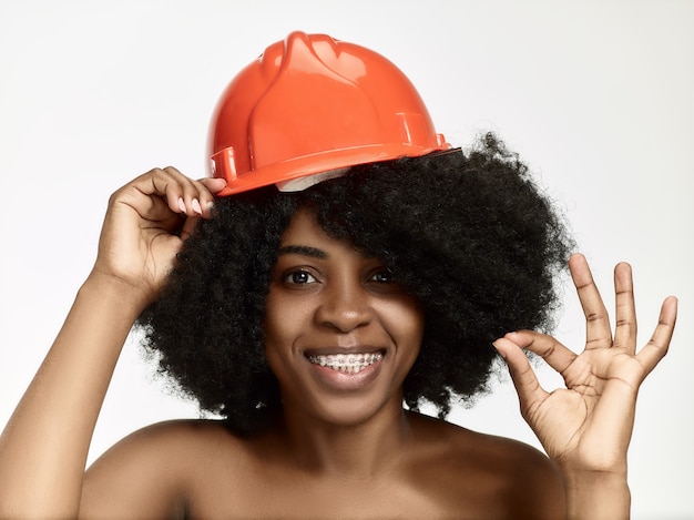 Free photo portrait of confident female worker in orange helmet