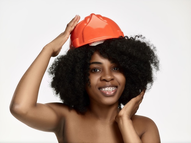 Portrait of confident female worker in orange helmet
