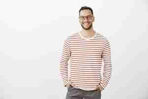 Free photo portrait of confident friendly caucasian employer in black glasses and striped pullover