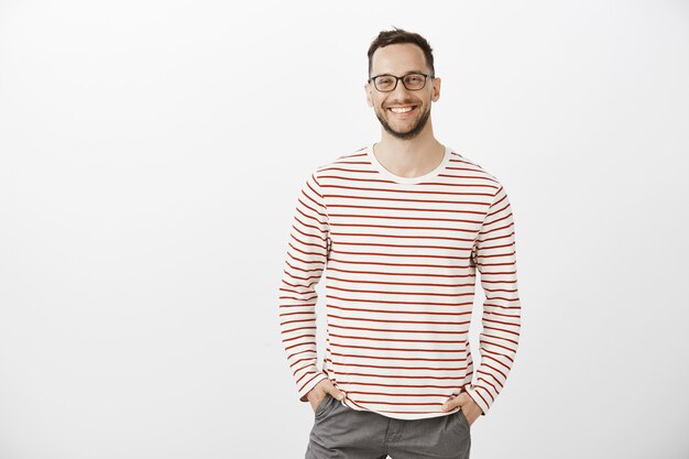 Portrait of confident friendly Caucasian employer in black glasses and striped pullover