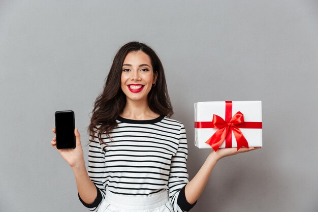 Free photo portrait of a confident girl showing blank screen mobile phone