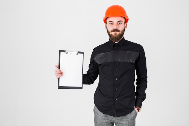 Portrait of confident male architect holding clipboard against white backdrop