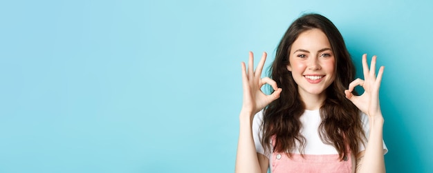 Free photo portrait of confident smiling woman showing ok gesture say okay agree with you approve and recommend