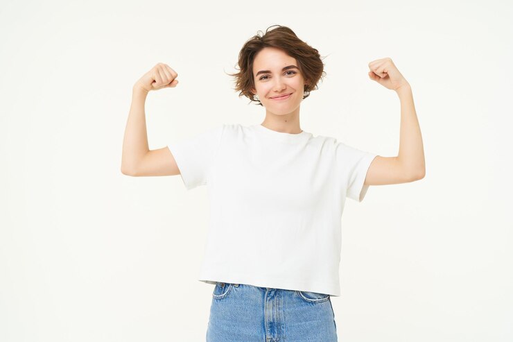 Free Photo portrait of confident and strong young woman flexing biceps shows her muscles on arms with proud