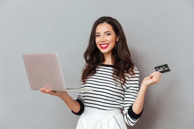 Portrait of a confident woman holding laptop computer