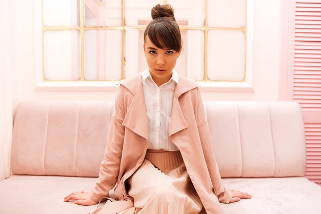 Portrait of a confident woman sitting on a sofa indoors