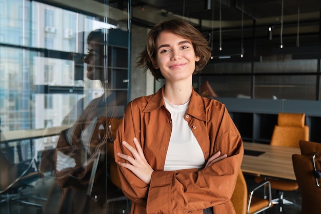 Free photo portrait of confident young businesswoman digital nomad posing in her office wearing casual clothes