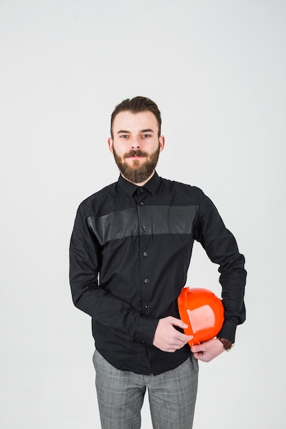 Portrait of confident young male engineer against white backdrop