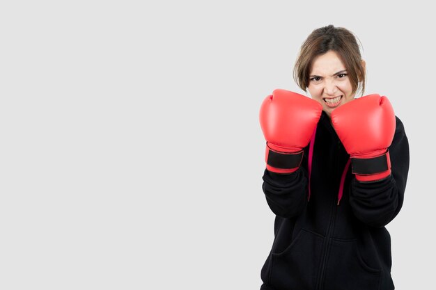 Portrait of a confident young sportswoman doing boxing exercises . High quality photo