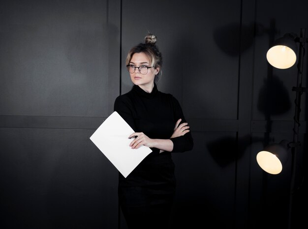 Portrait of confident young woman holding papers