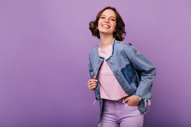 Portrait of confident young woman in trendy oversize jacket. Elegant smiling girl posing with pleasure.